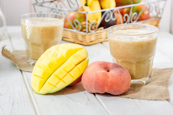 Frullato di mango e pesca sulla tavola di legno con ingredienti . — Foto Stock