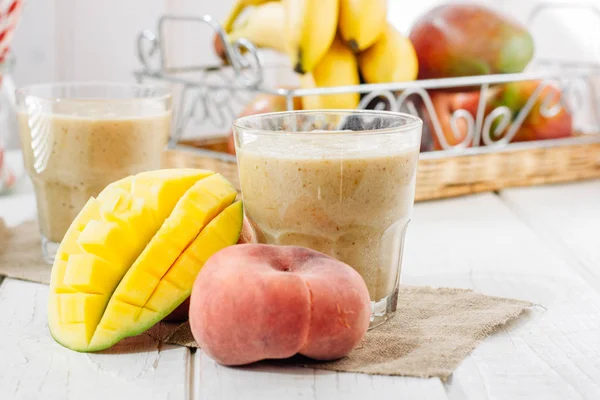 Mango ve şeftali smoothie malzemeler ahşap tablo.