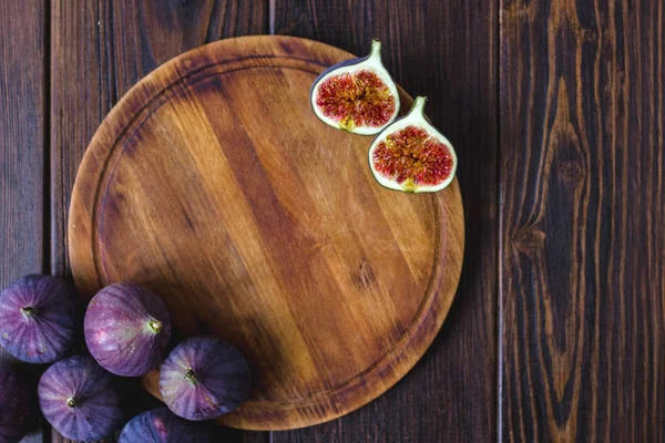 Round kitchen board with fig fruits on it with place for text.