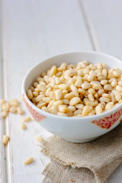 Çam fıstığı ahşap masa üzerinde bir seramik kase.