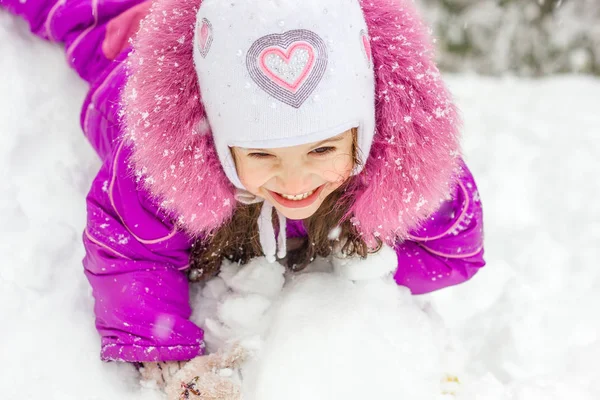 Kız çocuk slayt üzerinde karlı kış gününde evlat..
