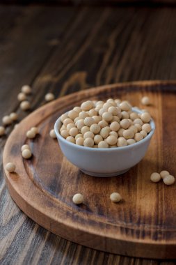 Ahşap masanın üzerinde beyaz seramik kasede organik soya fasulyesi..