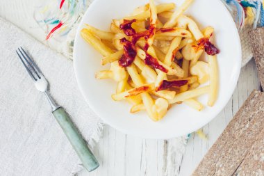 Domates soslu patates kızartması ve beyaz masada peynir..