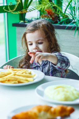 Restorandaki kız çocuk fast food yiyor..