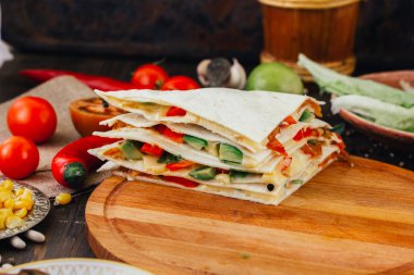 Tortilla ekmeği, fasulye, peynir ve sebzeli vejetaryen quesadilla..
