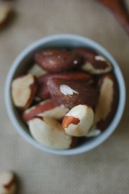 Brezilya fıstığı kahverengi kumaş üzerinde beyaz seramik kase yığını.