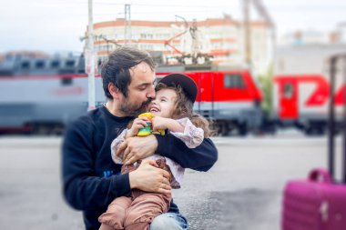 Babam kızıyla tren istasyonunda oynuyor.