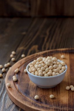 Ahşap masanın üzerinde beyaz seramik kasede organik soya fasulyesi..