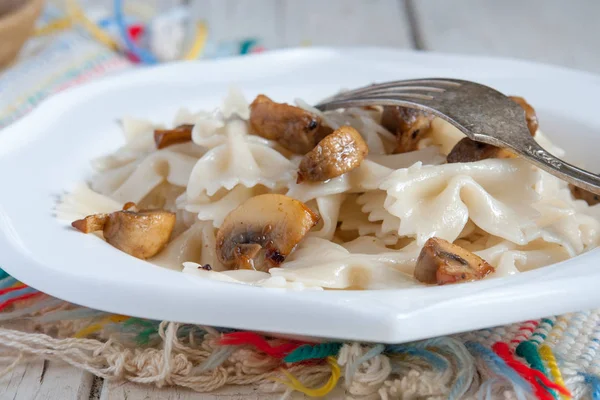 Фарфалле Паста - с грибами на белой тарелке — стоковое фото
