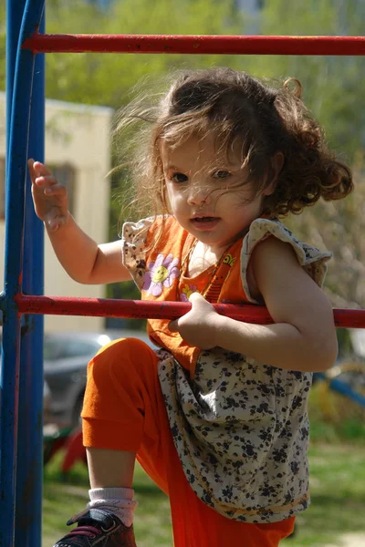 Adorável menina subindo escadas no parque infantil. — Fotografia de Stock