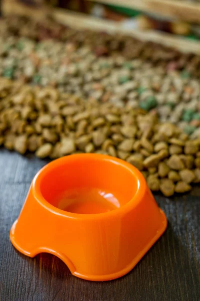 Cuenco naranja pequeño para alimentos para mascotas y alimentos secos como fondo. — Foto de Stock