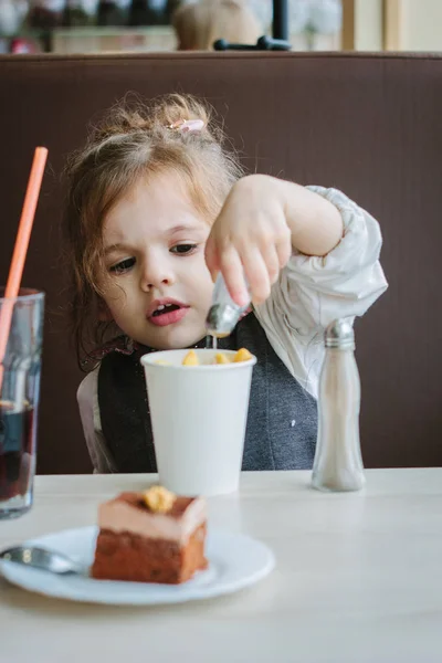 Маленькая девочка ест картошку фри в ресторане. — стоковое фото