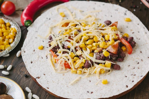 Vegetables, beans and cheese over tortilla bread - vegetarian mexican salad tacos.