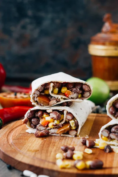 Nice vegetarian burrito over black table on wooden board. — Stock Photo, Image