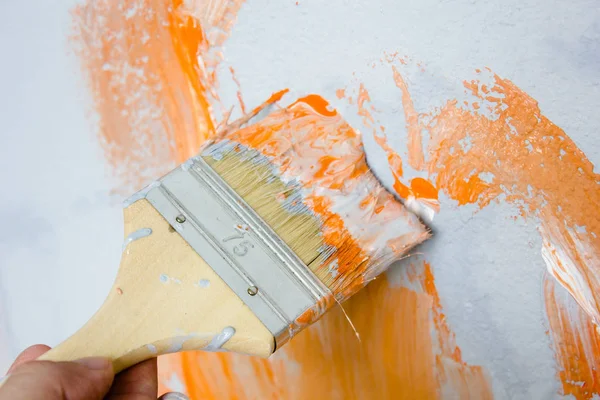 Štětec s oranžovou a bílou barvou jako rekonstrukce a tvorba — Stock fotografie
