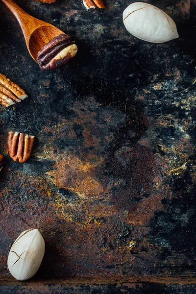 Pekan ořech a dřevěná lžíce na rustikálním stole. — Stock fotografie