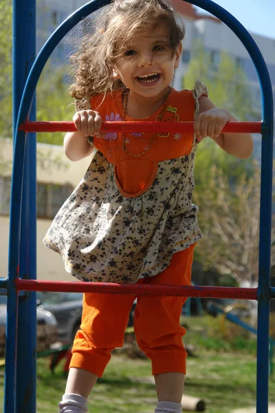 Adorável menina subindo escadas no parque infantil. — Fotografia de Stock