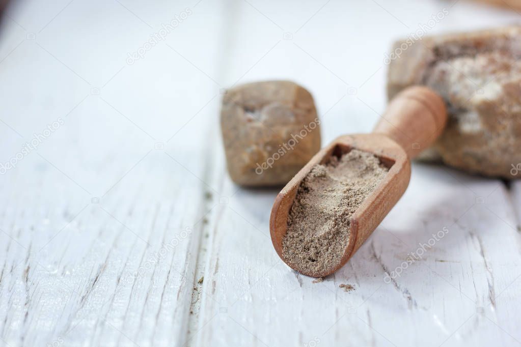 Asafoetida spice in wooden scoop on table