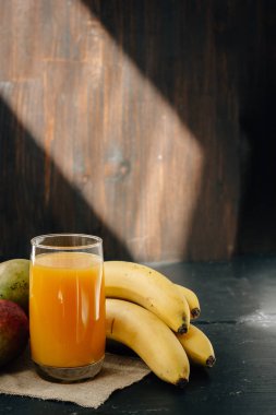 Siyah yüzey üzerinde muz ve mango suyu