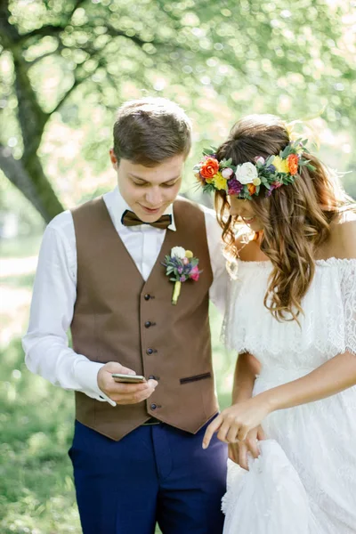 Bruiloft Paar Glimlachen Terwijl Zoek Naar Smartphone — Stockfoto