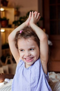 Çocuk kız gülümseyerek ve holding namaste içinde eller