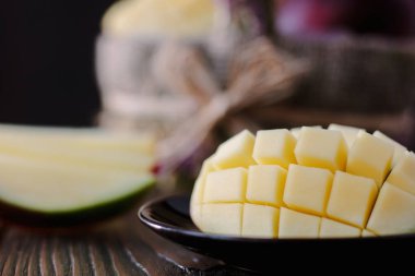 Taze ve sulu mango, ahşap masanın üzerinde ikiye bölünmüş.