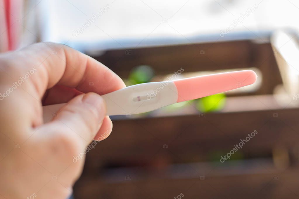 Human hand holds a negative pregnancy test
