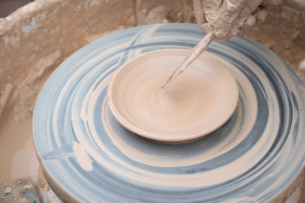 Clay plate rotating on the pottery wheel.