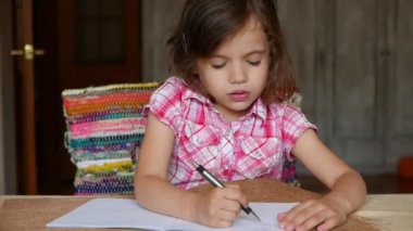 Evde çizim yapan sevimli küçük bir kızın görüntüleri.