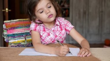 Evde ödev yapan sevimli küçük bir kızın görüntüleri.