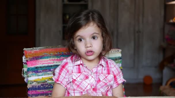 Πλάνα Αξιολάτρευτο Κοριτσάκι Κάθεται Στο Τραπέζι Στο Σπίτι — Αρχείο Βίντεο