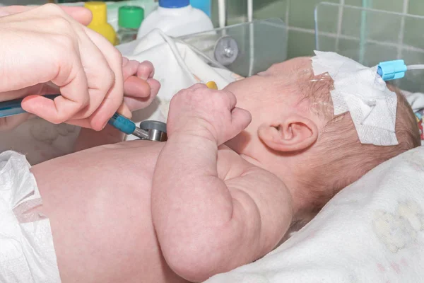 Médecin faisant auscultation nouveau-né avec cathéter intraveineux périphérique dans la veine de sa tête dans l'unité de soins intensifs néonatals — Photo