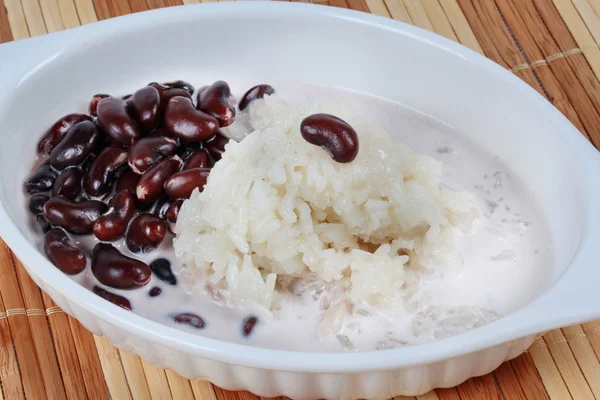 Frijol negro y arroz pegajoso en crema de coco dulce rematado leche de coco en marrón . — Foto de Stock