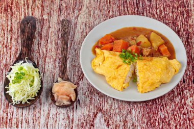 Omlet pirinç Japon sarı köri dilimlenmiş lahana ve turşu zencefil ile tepesinde.