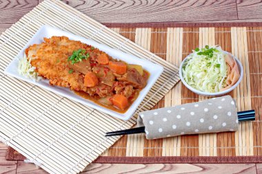 Japon tarzı derin kızarmış dolly balık dilimlenmiş lahana ve turşu zencefil ile sarı köri tepesinde.