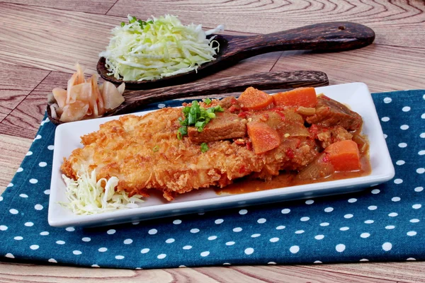 Primer plano de pescado dolly frito en estilo japonés cubierto de curry amarillo con repollo en rodajas y jengibre en escabeche. Enfoque selectivo . — Foto de Stock