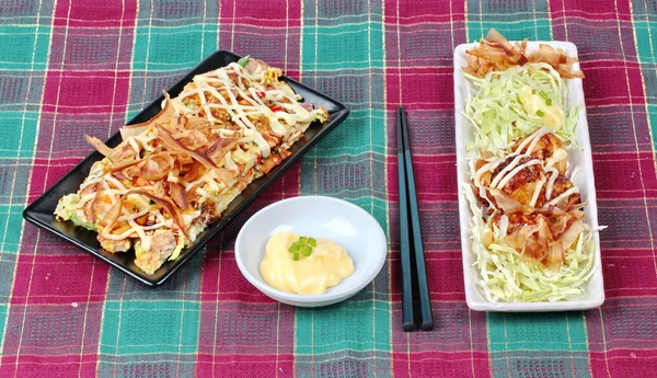 Grill flour wrap squid (as Takoyaki) served with Japan pizza (as Okonomiyaki) and side dish.