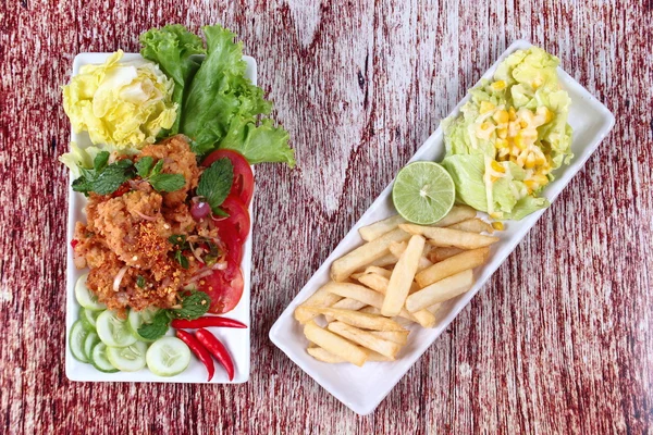 Ensalada de pollo frito picante (Yum Kai Zap en tailandés) servido ensalada de verduras mixtas y fuegos franceses . — Foto de Stock