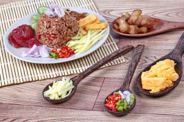 Yeşil mango rulo, Çin sosis, çıtır kurutulmuş balık, karides, biber, soğan, karides hamur (Kao Klok Kapi) ile rice Fried Yasemin tatlı domuz eti, salatalık ve çırpılmış yumurta ilave edin