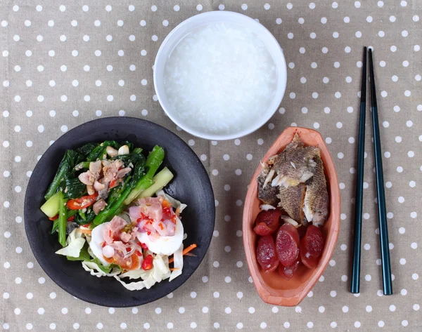 Fait maison, gruau de riz et plat d'accompagnement comme râpé de poisson frit séché au soleil, saucisse chinoise, salade d'œufs salés épicés et chou frits avec du poisson salé . — Photo