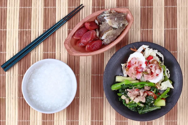 Fait maison, gruau de riz et plat d'accompagnement comme râpé de poisson frit séché au soleil, saucisse chinoise, salade d'œufs salés épicés et chou frits avec du poisson salé . — Photo