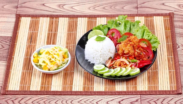 Buatan rumah, beras Jasmine dengan salad ayam goreng pedas (Khao Yum Kai Zap di Thailand) diatapi mentimun yang diiris, tomat, setengah lemon dan selada disajikan dengan salad sayuran campuran . — Stok Foto