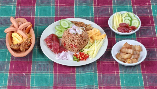Thailändisches Essen, gebratener Jasminreis mit Garnelenpaste, (kao klok kapi) mit grünem Mangobrötchen, chinesischer Wurst, knusprigem Trockenfisch, Garnelen, Chili, Schalotten, süßem Schweinefleisch, Gurken und Rührei . — Stockfoto