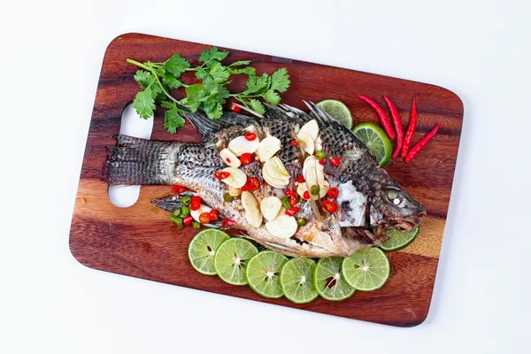 Pesce alla tilapia condito con limone condito con zenzero acido piccante e peperoncino al macellaio servito. (Chiama Pla Nil Nuang Manoaw in Thai) isolato sfondo bianco . — Foto Stock