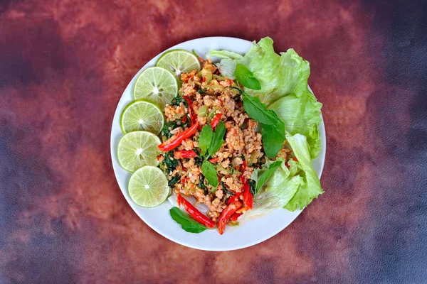 Thai food,Fried spicy basil with minced pork topped sliced green lemon and and lettuce . — Stock Photo, Image