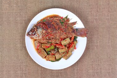 Derin yağda kızartılmış tilapia Balık baharatlı kızarmış patlıcan tepesinde. 