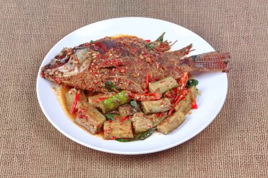 Derin yağda kızartılmış tilapia Balık baharatlı kızarmış patlıcan tepesinde. 