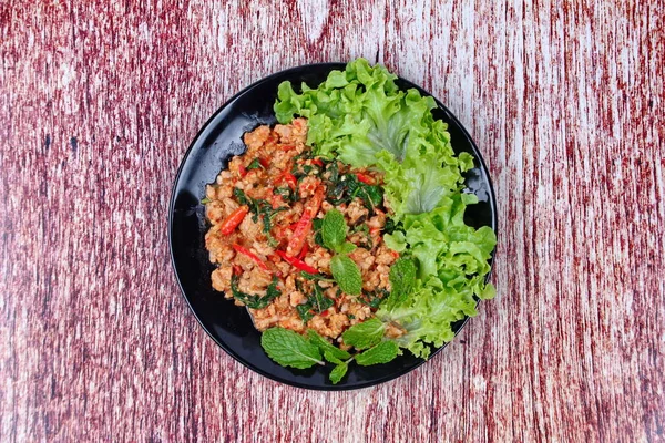 Fried spicy basil with minced pork topped lettuce. — Stock Photo, Image