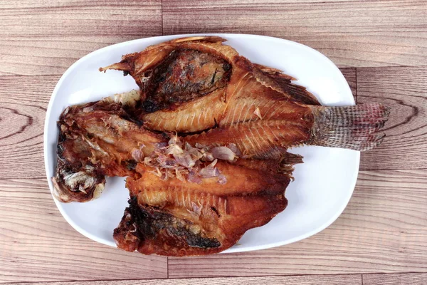 Pescado de tilapia frito cubierto de cebolla roja crujiente . — Foto de Stock