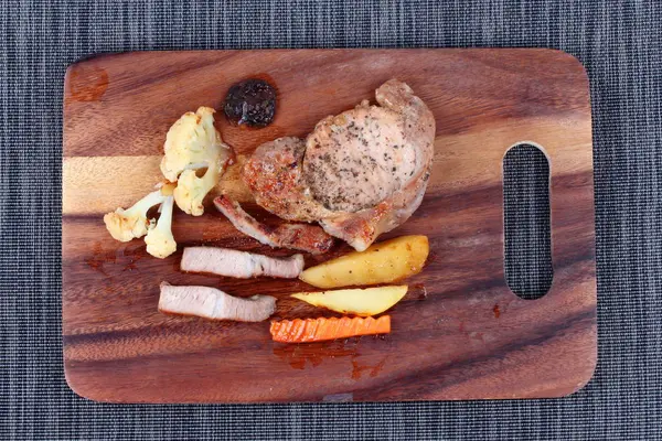 Domuz eti biftek kasap üzerinde karışık sebze ile servis. — Stok fotoğraf